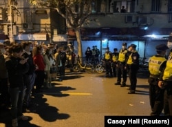 Demonstrantçylar we hytaý poliseýleri. Şanhaý, 2022-nji ýylyň 27-nji noýabr agşamy