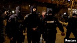 Andrew Tate (center) and Tristan Tate (center right) are escorted by police officers in Bucharest after being detained on December 29.
