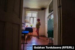 Башталгыч класстын мугалими Айтурган Асан кызы. (Сүрөттүн оң жагындагы бурчта мештин орду байкалып турат).