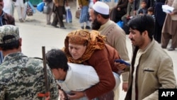 آرشیف - یک مرد افغان که مادر مریض خود را به پشتش انتقال می‌دهد در مرز میان افغانستان و پاکستان