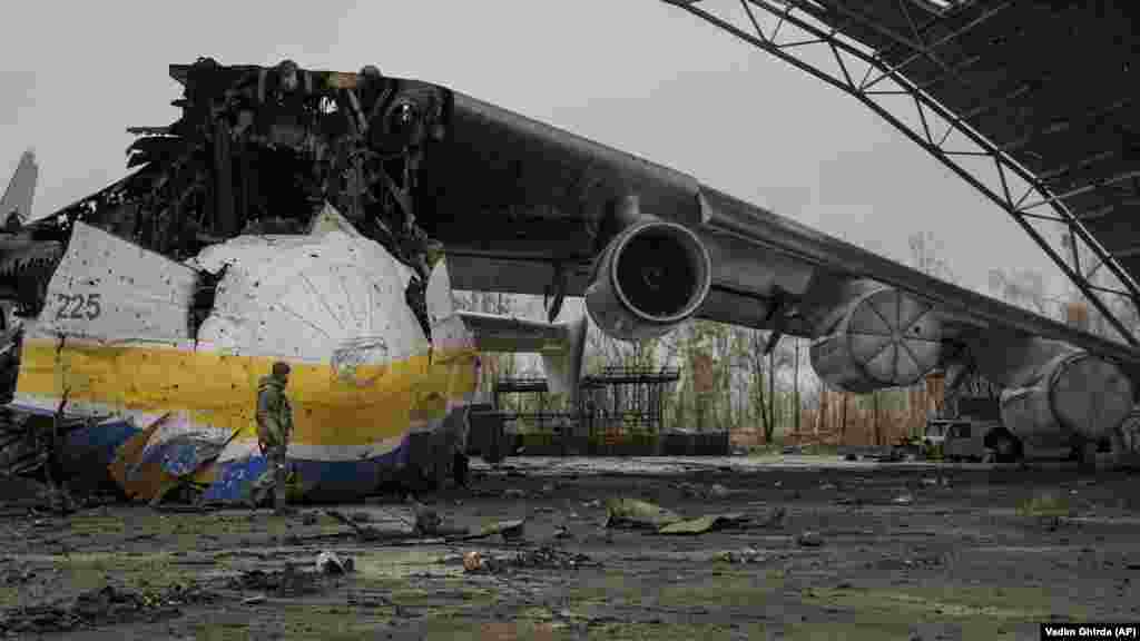 A Ukrainian soldier walks by the remains of the Antonov An-225 Mriya transport plane on April 2, 2022. The Mriya, which had been the world&#39;s largest aircraft, was destroyed by a Russian strike on February 27 during fighting at Antonov airport in Hostomel. The Mriya, which means &quot;dream&quot; or &quot;inspiration,&quot; was beloved by aviation enthusiasts around the world.