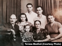 Сім’я Віри Могильної в Києві у період 1960-65-х років. Її прізвище було тоді Сюмар (на світлині вона сидить поруч зі своєю першою внучкою Валею Бенедюк), за яким знали її в Національному академічному драматичному театрі імені Івана Франка, де влаштувалася гардеробницею в акторській гардеробній і відпрацювала там кілька декад до самої пенсії. Завдяки їй я не тільки насолоджувалася українською сценічною драмою, а й зблизька (вона жартувала: «Впритул!») бачила провідних акторів театру, зокрема легендарних Наталю Ужвій й Миколу Яковченка, Михайла Задніпровського й Павла Морозенка, який після головної ролі в кінокартині «Роман і Франческа» купався в славі… Одного разу, прикипівши до стільця, я стала свідком тієї миті, коли Світлана Коркошко, після своєї ролі в фільмі «Загибель ескадри» за твором Олександра Корнійчука, забігла за своєю валізою – перед відбуттям до МХАТу. Красива, з короткою зачіскою, в модному букльованому костюмчику бузкового кольору, від якого в мене, підлітка, аж дух перехопило… Я все питала потім свою хрещену, чим їй не підходив Київ, а вона задумливо відповідала, помішуючи склянку чаю: «А знаєш, скільки їх відростило крила на нашій землі, щоб потім відлетіти на Москву?!..»