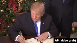 Трамп өз чечимине кол коюп жаткан учуру. 