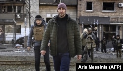 Міський голова Києва Віталій Кличко (ліворуч) і його брат Володимир Кличко біля житлового будинку, зруйнованого внаслідок російського вторгнення до України. Київ, 14 березня 2022 року