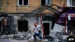 Людина залишає зруйновану внаслідок бойових дій будівлю, Донецьк, 20 серпня 2014 року