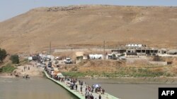 Iraq -- Displaced Iraqis from the Yezidi community cross the Iraqi-Syrian border along the Fishkhabur bridge over the Tigris River at the Fishkhabur crossing, in northern Iraq, August 11, 2014