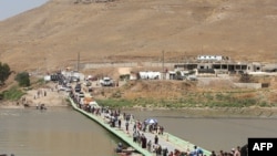 Եզդիները Տիգրիս գետի Ֆիշխաբուր կամրջով հատում են սահմանը՝ Սիրիայից վերադառնալով Իրաք, 11-ը օգոստոսի, 2014թ․