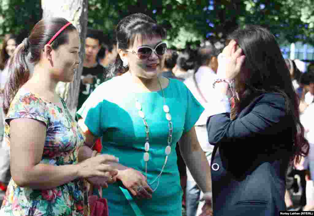 Родители и дети во дворе школы после мероприятия &quot;Первый звонок&quot;.