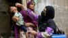 A health worker in Karachi administers polio drops to a child for vaccination on May 26, the first day of a nationwide week-long poliovirus eradication campaign.
