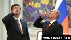 Кытайдын лидери Си Цзиньпин (солдо) жана Орусиянын президенти Владимир Путин 2014-жылы Шанхайда газ келишимине кол койгондон кийин