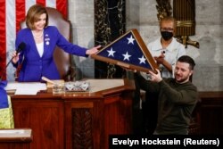 Президент України Володимир Зеленський приймає американський прапор від спікера Палати представників США Ненсі Пелосі під час засідання Конгресу Сполучених Штатів. Вашингтон, 21 грудня 2022 року