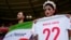 Iran fans hold a "Women, life, freedom" Iranian flag and a replica shirt in memory of Mahsa Amini inside the stadium in Qatar before the match with Wales on November 25.