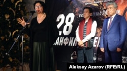 Внучка генерала Ивана Панфилова Алуа Байкадамова (у микрофона), президент киностудии «Казахфильм Бахыт Каирбеков (слева на заднем плане), министр культуры и спорта Казахстана Арыстанбек Мухамедиулы на премьере фильма «28 панфиловцев». Алматы, 18 ноября 2016 года.