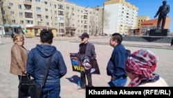 Юрист Ербол Аккужанов на площади имени Ауэзова в городе Семей держит плакат надписью: «No war» («Нет войне»).  Семей, 15 апреля 2022 года 