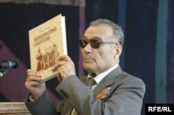 Rahym Esenow Türkmenistanda ýakylan "Baýramhan" kitabyny görkezýär. Praga, iýun, 2006.