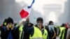 France -- A Yellow vest (Gilet jaune) protestor kicks a tear gas canister on the Champs Elysees in Paris, 24Nov2018