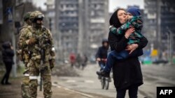 Цивільні поруч із російськими солдатами під час захоплення арією РФ Маріуполя. 12 квітня 2022 року