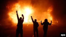 Демонстранттар өрттөлгөн дүкөндүн жанында. Фергюсон, 24-ноябрь, 2014-жыл. 