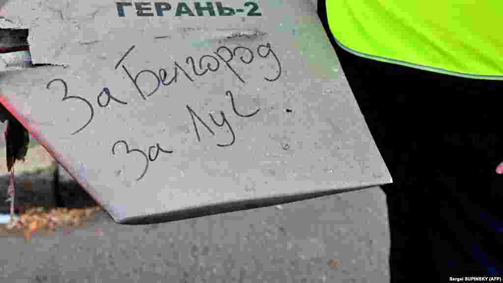 Поліцейський тримає в руках уламок дрона, на якому рукописний напис &laquo;За Бєлгород. За Луг&raquo;. Росія звинуватила Україну в ураженні цілей у Бєлгородській області поблизу кордону. Проросійські джерела новин у соцмережі Telegram повідомили, що Україна вночі завдала удару по аеропорту Бєлгорода. Українська влада обстріл Бєлгорода не коментувала. Провладні українські&nbsp;телеграм-канали&nbsp;не виключають, що до Бєлгорода могли прилетіти снаряди з боку Росії, яка обстрілювала Харків.