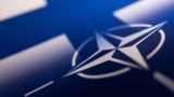 Лягатып NATO на фоне сьцягу Фінляндыі 