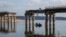 Civilians cross the Siverskiy Donets River by boat under a damaged bridge in the liberated city of Stariy Saltiv east of Kharkiv. It's estimated that Ukraine will need hundreds of billions of dollars over the next 10 years to rebuild its devastated economy and infrastructure. (file photo)