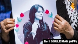 تصویری از مهسا امینی که در جریان تظاهرات توسط مردم در ایران حمل میشود