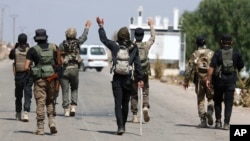 Bedouin fighters gather in the village of Busra al-Harir, northwest of Sweida city, while security forces cordon off the area in southern Syria on July 22.