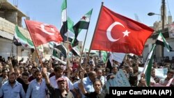 Идлиб провинциясында Сириянын өкмөттүк  күчтөрүнүн күтүлгөн чабуулуна каршы демонстрациялардын бири. 14-сентябрь, 2018-жыл. 