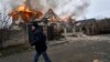 A local resident runs past a burning house hit by Russian shelling in Kherson, Ukraine, on January 6. 