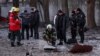 Emergency services and police officers examine parts of a drone at the site of a building destroyed by a Russian drone attack in Kyiv on December 14.