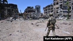 Російський військовий в розбомбленому Маріуполі, червень 2022 року