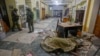 Russian military investigators stand near the body of a person killed by shelling at a youth center in Donetsk on December 6.
