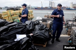 Военнослужащие Береговой охраны США осматривают конфискованные 25 тонн кокаина и и 7 тонн марихуаны, изъятые у латиноамериканских преступников в порту Эверглейдс в штате Флорида. 17 февраля 2022 года