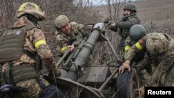 Ukrainian soldiers prepare to fire a mortar on the front line in the Kharkiv region. 