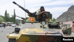 Kyrgyzstan -- A Kyrgyz serviceman sits on an armoured vehicle in the city of Osh, southern Kyrgyzstan, 15Jun2010