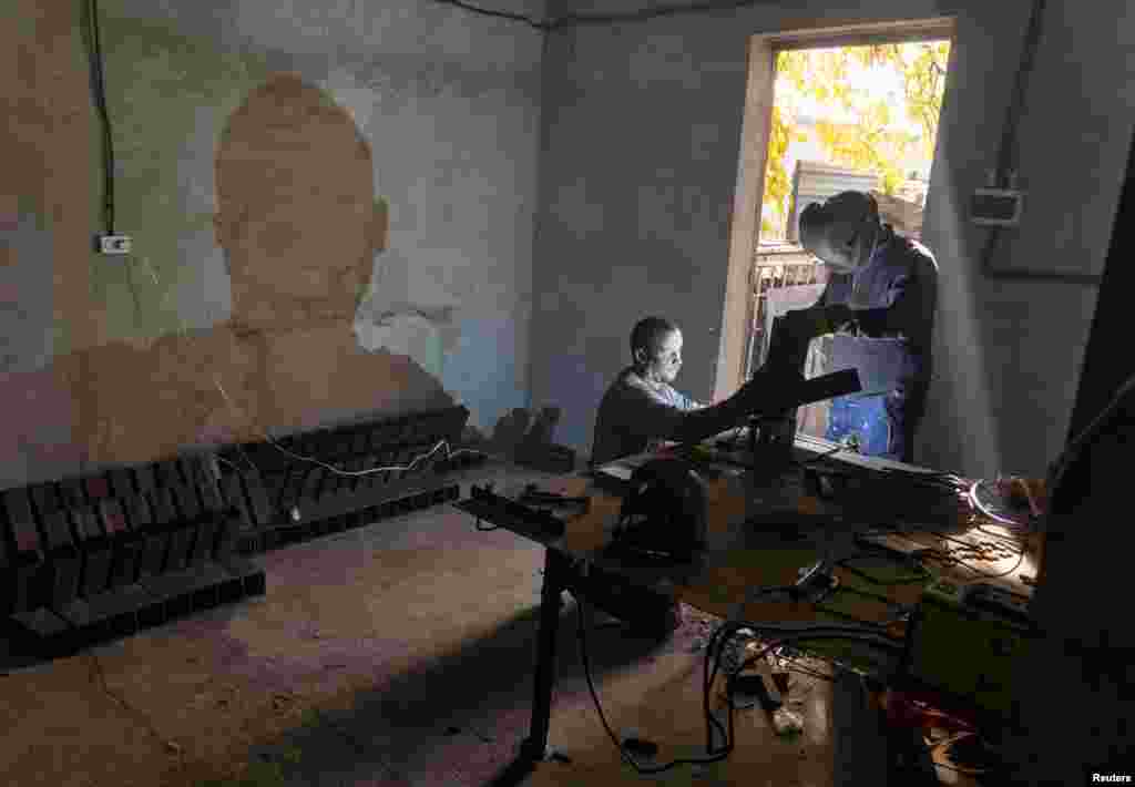 Ukrainian men weld the stoves in the Mykolayiv Region. Ramestam says money for material used in the stoves comes from foreign donations, while the Ukrainian workers building the appliances &quot;do it voluntarily, just to help their country.&quot;&nbsp;