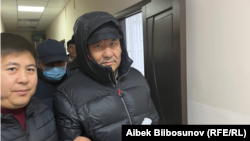 Азимбек Бекназаровду сот залынан алып чыгып бараткан учур. 