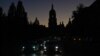 Vehicles drive along a street in Kyiv with the St. Sophia Cathedral silhouetted in the background as the city was plunged into near darkness following Russian military strikes on October 31. Ukraine suffered sweeping blackouts, while water supplies were cut for 80 percent of city residents.