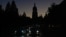 Vehicles drive along a street in Kyiv with the St. Sophia Cathedral silhouetted in the background as the city was plunged into near darkness following Russian military strikes on October 31. Ukraine suffered sweeping blackouts, while water supplies were cut for 80 percent of city residents.
