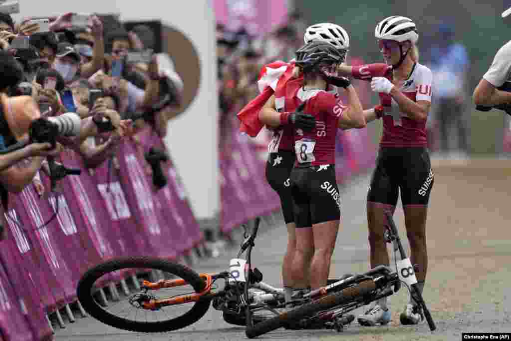 Швейцариялык Жоланда Нефф тоо велосипеди боюнча аялдар арасындагы жарышта&nbsp; экинчи орунду ээлеген Сина Фрей, үчүнчү орунду алган Линда Индергандды кучактап кубанууда.&nbsp;&nbsp;