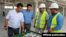 Самат Исабеков (сол жакта) жана ишкана кызматкерлери.