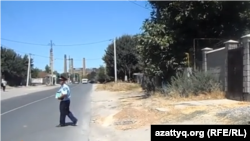 Полицейский стоит на месте взрыва в  микрорайоне Онтустик города Шымкента. 14 августа 2015 года.