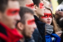 Учасники віча «Зупинимо капітуляцію!» із червоною лінією на обличчях під час здійснення «обходу» урядового кварталу. Київ, 6 жовтня 2019 року