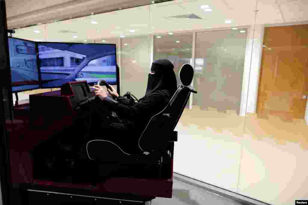 Одна из курсантов автошколы учится управлять автомобилем посредством учебного симулятора вождения..