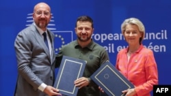 Ուկրաինայի նախագահ Վլադիմիր Զելենսկին, Եվրոպական խորհրդի նախագահ Շառլ Միշելը և Եվրահանձնաժողովի ղեկավար Ուրսուլա ֆոն դեր Լայենը անվտանգության ոլորտում համագործակցության մասին համաձայնագրի ստորագրման արարողության ժամանակ, Բրյուսել, 27-ը հունիսի, 2024թ.