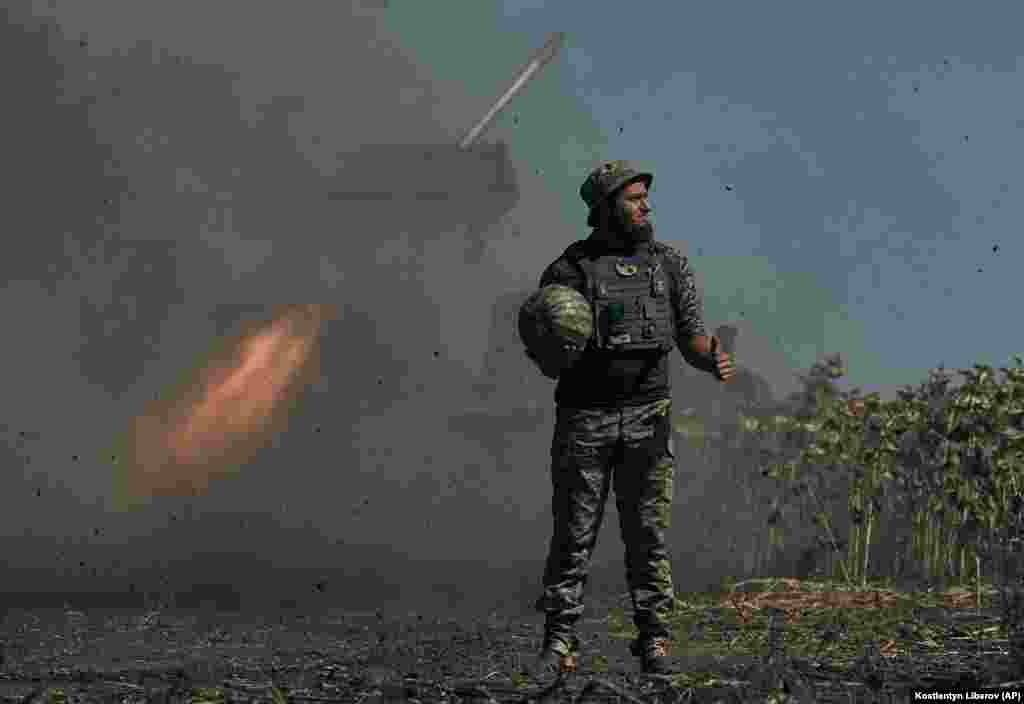 A Ukrainian soldier holding a watermelon gives a thumbs up as a rocket launches toward the front line in the Donetsk region on September 3, 2022. The fruit became the symbol of the Ukrainian military&#39;s counteroffensive operation to liberate the city of Kherson, which was occupied by Russian forces in March.