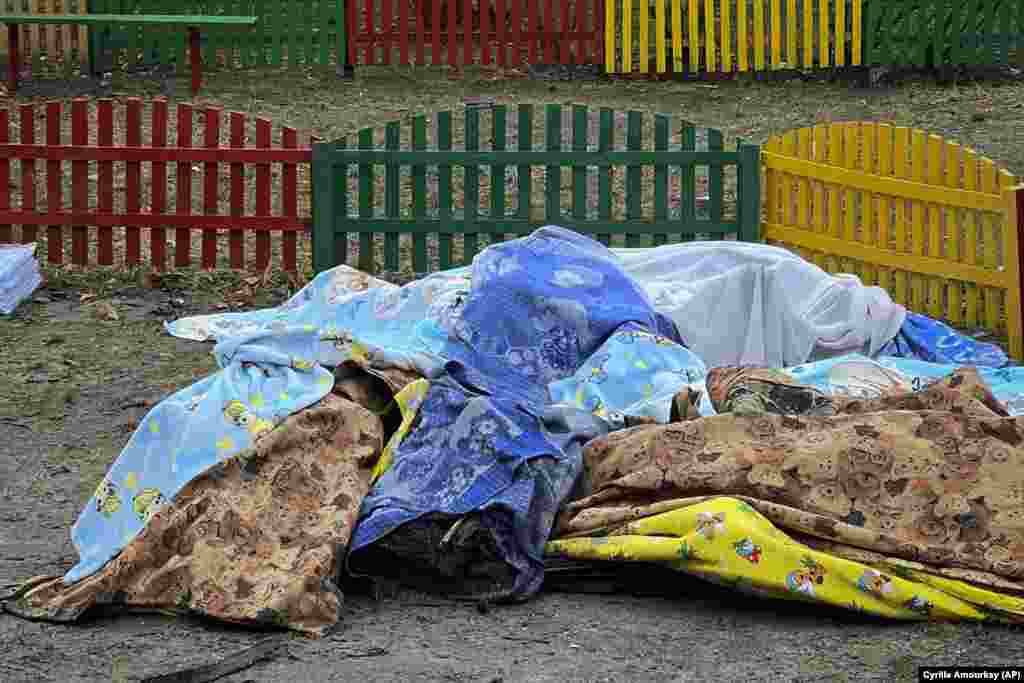 Dead bodies covered by blankets are seen in a kindergarten at the scene where the helicopter crashed.