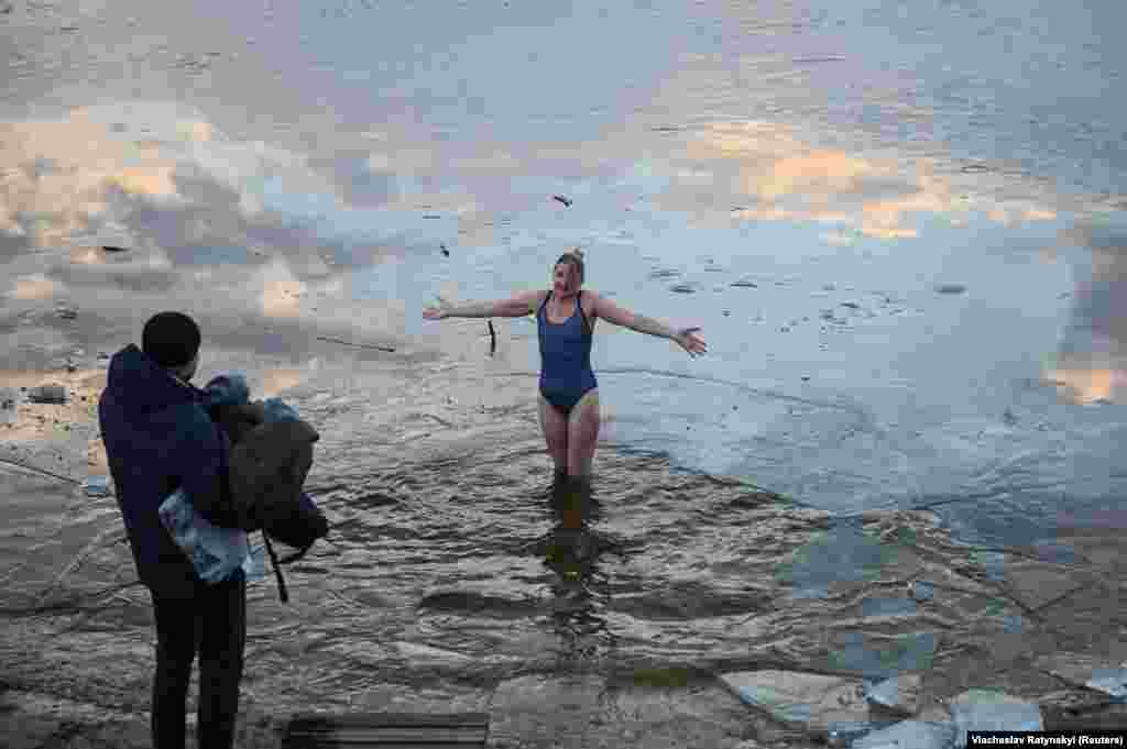 Жінка стоїть у крижаній воді, яка, як вважається, має чудодійну силу на Водохреща&nbsp; (християнське свята Хрещення Господнього за юліанським календарем). Буча, Київська область, Україна. 19 січня 2023 року
