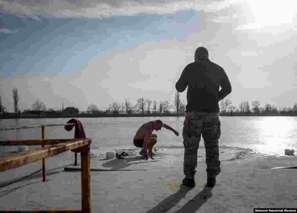 Українські військовослужбовці готуються пірнути в крижану воду на Водохреща (свято Хрещення Господнього) за юліанським календарем у час війни Росії проти України.&nbsp; Слов&#39;янськ, Донецька область, Україна. 19 січня 2023 року