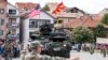 U.S. soldiers arrive on a tank during the presentation of their vehicles and weapons in Kumanovo on July 28, 2017.